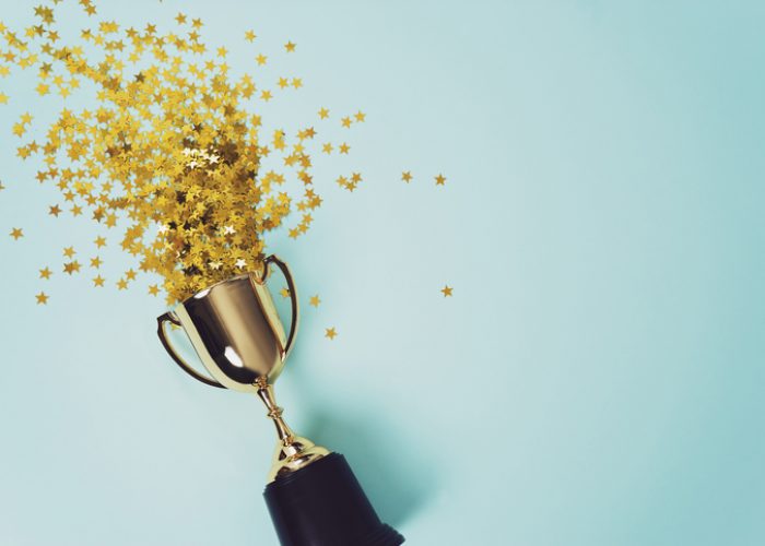 gold winner cup on blue background image of little gold cup , concept for winning or success